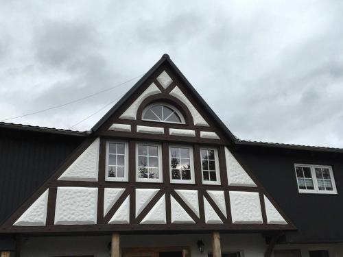 una casa con techo blanco y negro en Ferienhof Homann, en Lindenberg