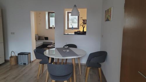 uma sala de jantar com uma mesa branca e cadeiras em Am Diemelradweg em Warburg