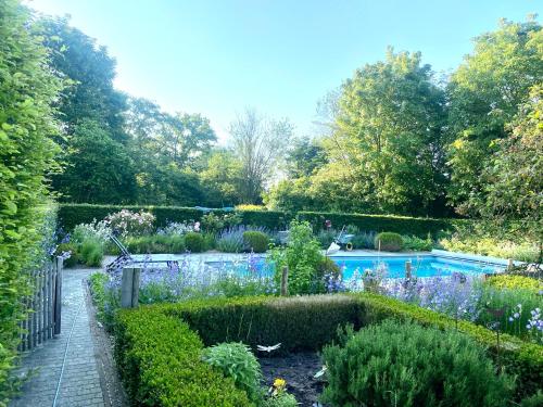 Mont-Saint-Guibert的住宿－Marie campagne，一个带游泳池和鲜花的花园