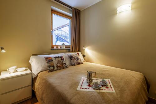 a bedroom with a bed with a tray on it at Maison Checrouit in Courmayeur