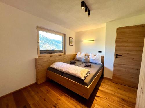 sypialnia z łóżkiem z oknem i drzwiami w obiekcie Appartement Hirner w mieście Fügenberg