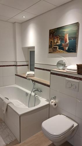 a bathroom with a tub and a toilet and a sink at Gasthof Hillig in Bad Gottleuba