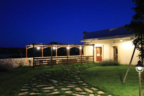 a house at night with a fence and lights at La Valle delle Rose in Massafra