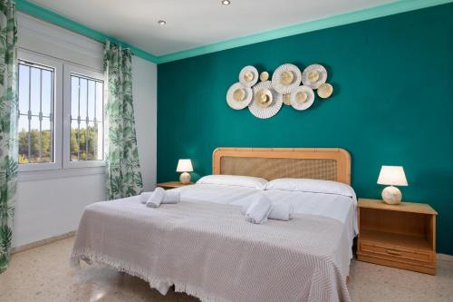 1 dormitorio con 1 cama grande y pared verde en Bellavista 89 en Dénia