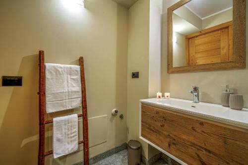 La salle de bains est pourvue d'un lavabo et d'un miroir. dans l'établissement Maison Checrouit, à Courmayeur