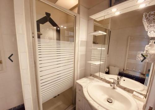 a white bathroom with a sink and a mirror at Studio Croisette in Cannes