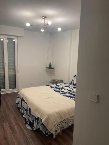 une chambre avec un lit dans une pièce blanche dans l'établissement Appartement de 75m2, à Gap