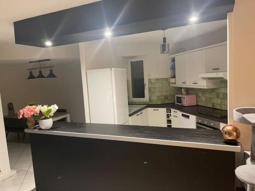 une cuisine avec des armoires blanches et un comptoir noir dans l'établissement Appartement de 75m2, à Gap