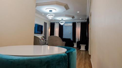 a room with a white table and a blue couch at House 575 in Abuja