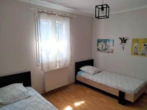 une chambre avec deux lits et une fenêtre dans l'établissement Grande villa avec piscine en Provence, à Beaucaire