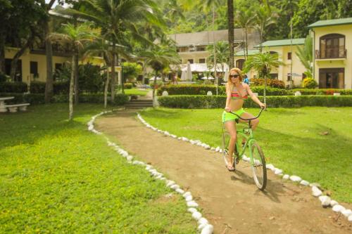 a woman in a bikini riding a bike down a path at Club del Mar Oceanfront in Jacó