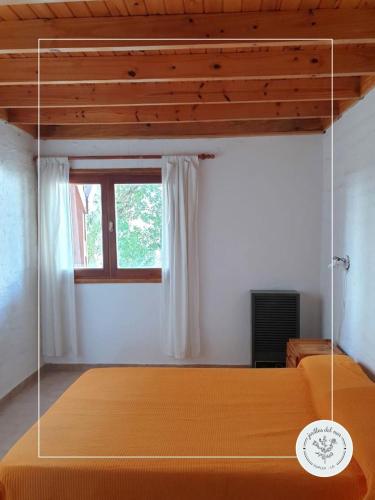 a bed in a room with a window at Jarillas del Mar in Las Grutas