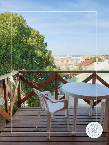 a white table and a chair on a balcony at Jarillas del Mar in Las Grutas