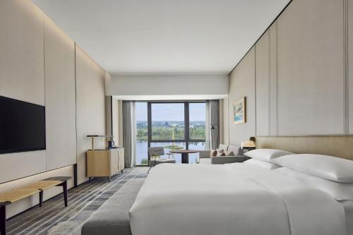 een hotelkamer met een groot bed en een televisie bij Sheraton Chengdu Pidu in Chengdu