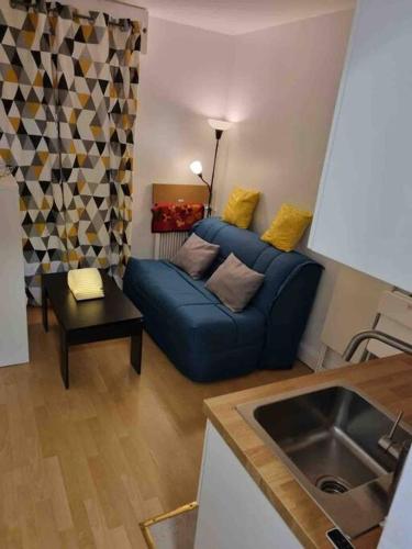 un salon avec un canapé bleu et une table dans l'établissement Mignonnette, à Paris