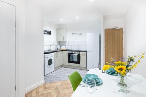 a kitchen with a table with a vase of flowers at Paradise Suite in Portsmouth