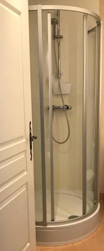 une douche avec une porte vitrée dans une salle de bain dans l'établissement La Bergerie du Village, à Domme