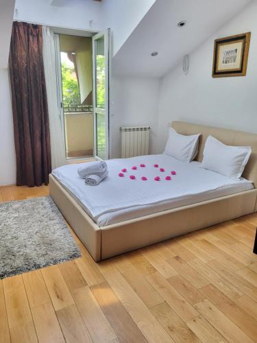 a bedroom with a large bed with red roses on it at Open Space Spa Apartment Monza National Arena in Colonişti