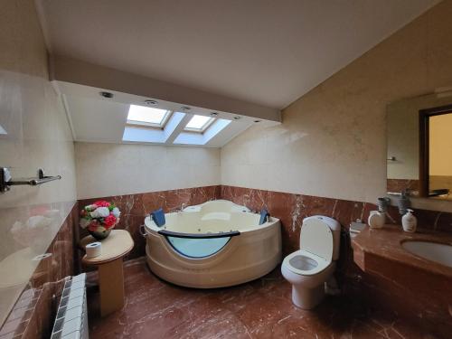 La salle de bains est pourvue d'une baignoire, de toilettes et d'un lavabo. dans l'établissement Open Space Spa Apartment Monza National Arena, à Colonişti