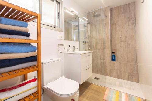 a bathroom with a shower and a toilet and towels at Ronda 3 con enorme terraza soleada in Fuengirola