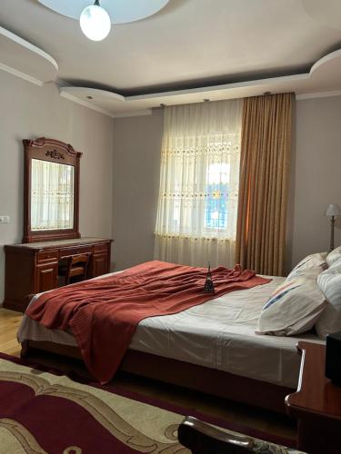 a bedroom with a bed and a desk and a window at Guesthouse TEA in Kutaisi