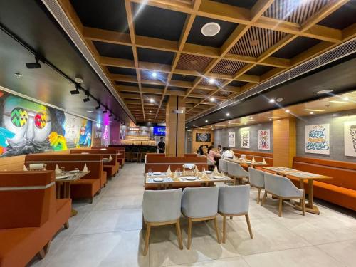 a restaurant with wooden tables and chairs and people eating at Hotel Tamarind in Sohāna