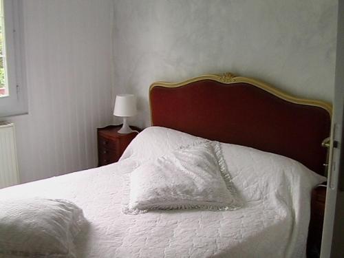 a bedroom with a white bed with a red headboard at Les ID de Saint Emilion in Saint-Émilion