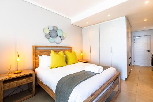 a bedroom with a large bed with yellow pillows at The Tyne Luxury Apartments in Durban