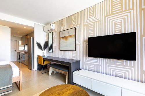a living room with a piano and a television on a wall at The Tyne Luxury Apartments in Durban