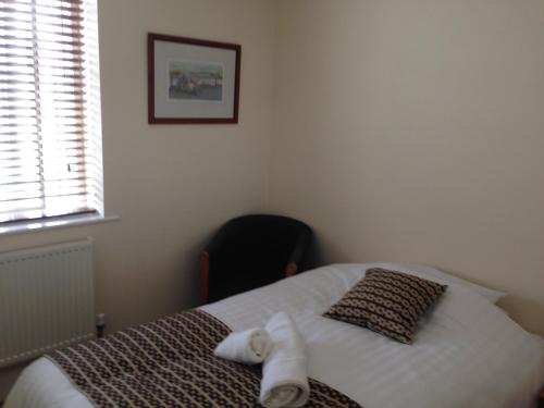 a bedroom with a bed with towels on it at Victoria hotel in Holywell