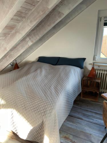 a bedroom with a white bed with blue pillows at Ferienwohnung Alex Mayer in Langenargen