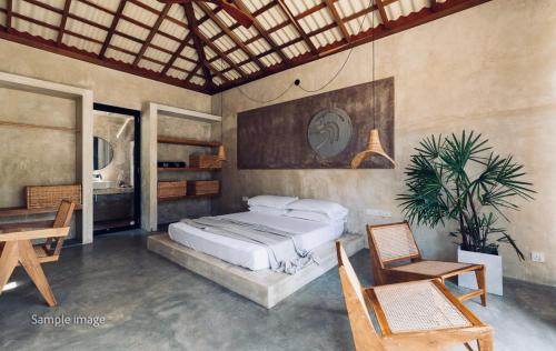 um quarto com uma cama, uma mesa e cadeiras em Swell Shacks em Matara