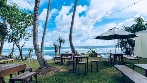 un groupe de tables et de chaises avec la plage en arrière-plan dans l'établissement Swell Shacks, à Matara