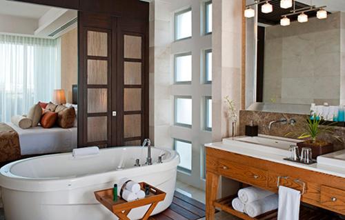 a large bathroom with a tub and a bed at Grand Luxxe with free Golf in Nuevo Vallarta 
