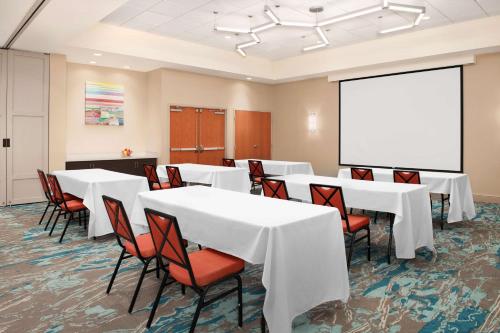 a conference room with white tables and chairs and a whiteboard at Hilton Garden Inn Solomons in Dowell