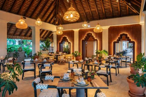 a restaurant with tables and chairs and potted plants at Hilton Mauritius Resort & Spa in Flic-en-Flac