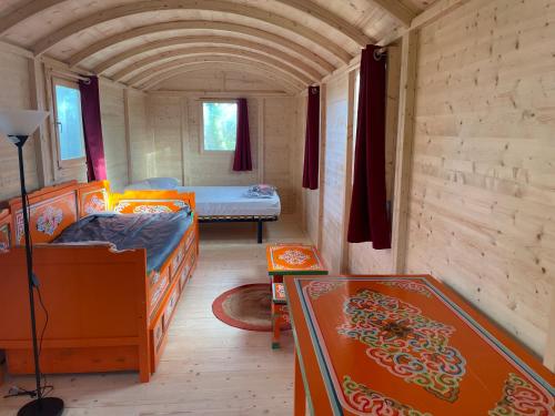 a room with two beds in a small room at Le Village Insolite yourte et roulotte in Saint-Benoît-des-Ondes