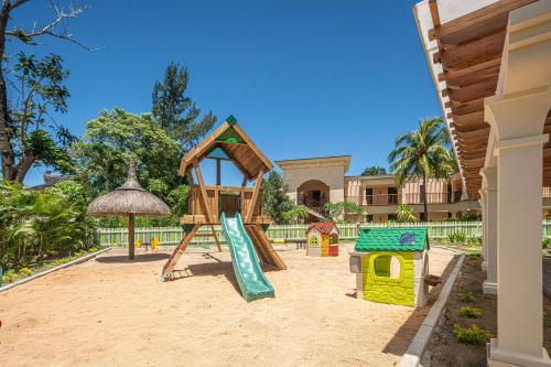 a playground in front of a house with a slide at Hilton Mauritius Resort & Spa in Flic-en-Flac