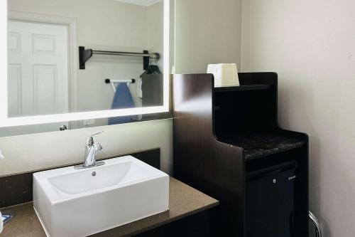 y baño con lavabo blanco y espejo. en Rodeway Inn Lemon Grove San Diego East, en Lemon Grove