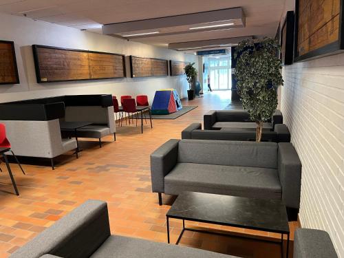 a waiting room with couches and a piano at Hirtshals Idrætscenter - Vandrehjem - Hostel in Hirtshals