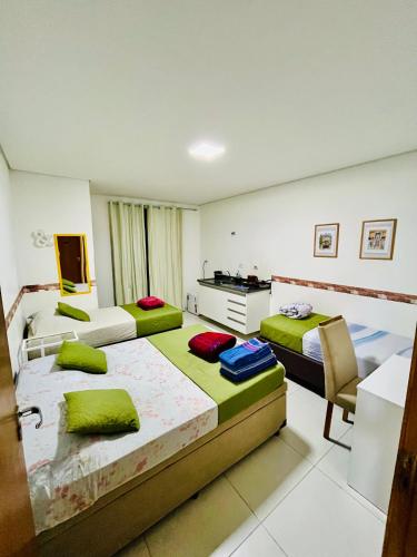 a hotel room with two beds and a desk at H34 Hotel in Guarulhos