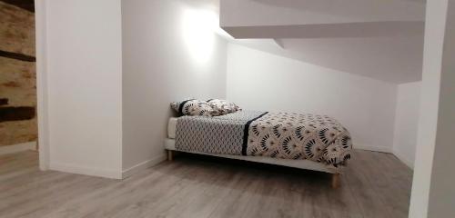 ein Schlafzimmer mit einem Bett in einer weißen Wand in der Unterkunft Appartement 2 chambres in Champdeniers