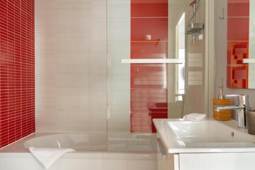 une salle de bain avec une baignoire et un lavabo dans l'établissement Epicea- Spacieux 3 chambres avec parking., à Nantes