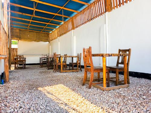 Habitación con mesa y sillas de madera. en Raha house en Nungwi