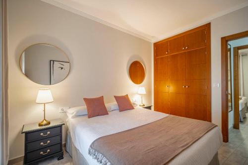 a bedroom with a large bed and a mirror at La Sultana de Vejer in Vejer de la Frontera