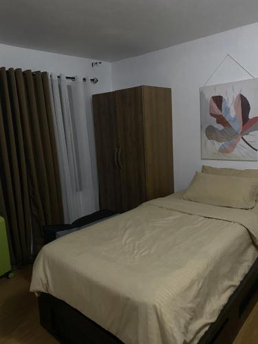 1 dormitorio con 1 cama grande y armarios de madera en Urban Deca Homes Tisa, en Cebú