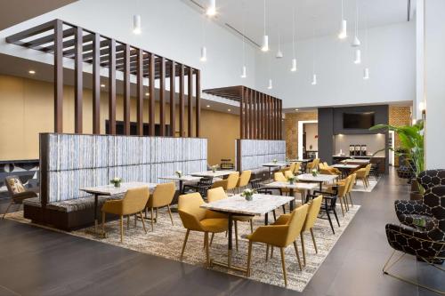 a restaurant with tables and chairs in a room at Hampton Inn & Suites Rochester Downtown in Rochester