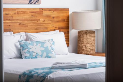 Una cama con una almohada y una lámpara. en Bargara Blue Resort, en Bargara