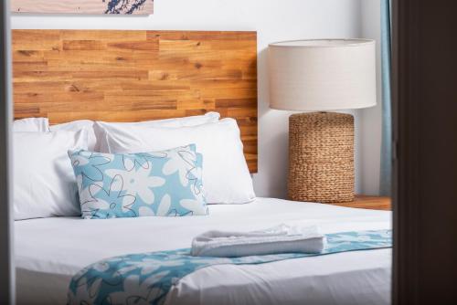 a bed with a pillow and a lamp on it at Bargara Blue Resort in Bargara