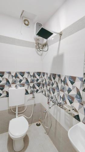 a bathroom with a toilet and a sink at Hotel Dwarika in Chandrapur